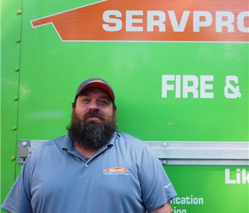 SERVPRO employee pictured in front of green background