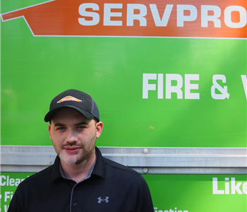 SERVPRO employee pictured in front of green background